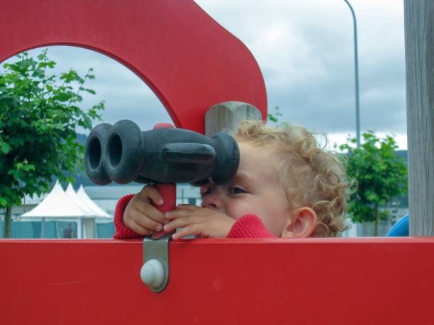 istock child looking through binoculars in the playground 1453176705