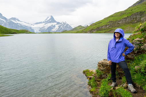 mature woman hiking in the rain near bachalpsee in the Swiss Alps
