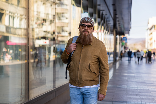 Portrait of urban mid-adult Caucasian man with long beard, in the city