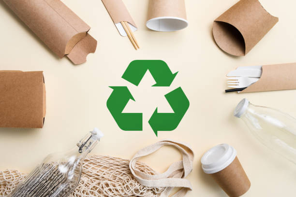 istock Eco-friendly items made from biodegradable materials lie around a green recycling sign. Waste recycling concept 1453179296