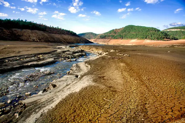 A drinking water dam that has been drained due to drought and unconscious use of water