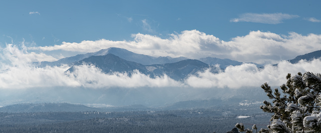 Pikes Peak in the clouds, scene with fresh snow seen from 15 miles northeast in Monument, Colorado, USA, North America