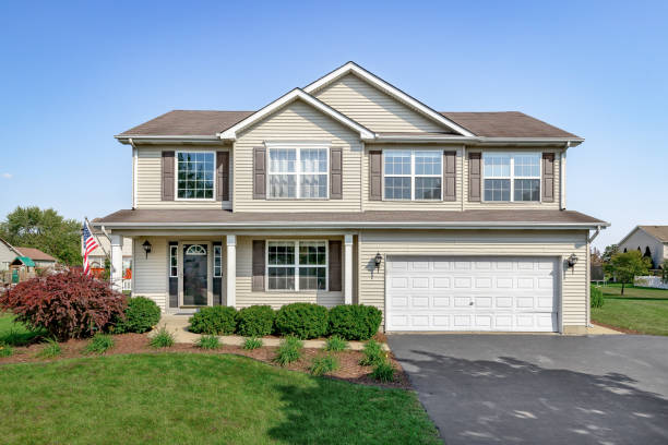 A suburban home with brown siding and shutters. Aurora, IL, USA - September 1, 2020: A new suburban house with tan siding, brown window shutters, and a front porch. empty home garage stock pictures, royalty-free photos & images