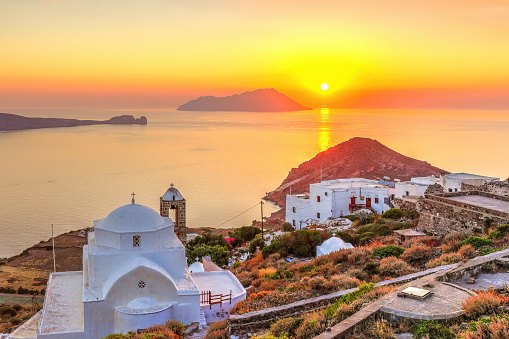 The sunset from the castle above the village of Plaka in Milos, Greece. Below the church of The Assumption of the Virgin Mary or Panaghia Skiniotissa and the church of Panaghia Thalassitra.