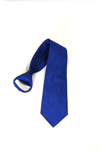 A vertical shot of a blue polyester necktie isolated on a white background.