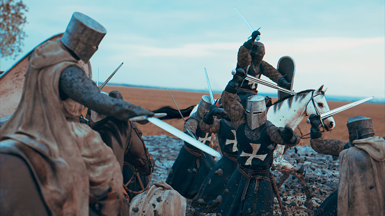 War between soldiers on a medieval battlefield. The soldiers wear chain armor and fights with swords. They also wear helmets and some of them rides horses. The ground is full of mud and the mud sprays all over the place, when the soldiers fight.