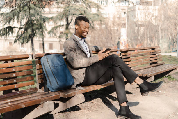 istock Young African American enjoying in the park and using smartphone 1453210376