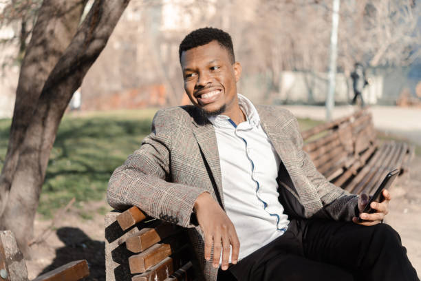 istock Young African American enjoying in the park and using smartphone 1453210377