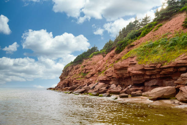 Cloudy basin head rocks 2 Basin Head beach, Prince Edward Island with red rock cliffs cavendish beach at prince edward island national park canada stock pictures, royalty-free photos & images