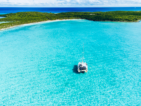 Sailing catamaran on anchorage in coral waters in Bahamas