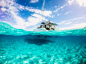 Semi underwater picture of Catamaran Anchored in turquoise blue water