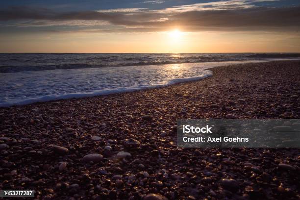 Sunset On Beach With Small Stones In Foreground Stock Photo - Download Image Now - Beach, Beauty, Beauty In Nature