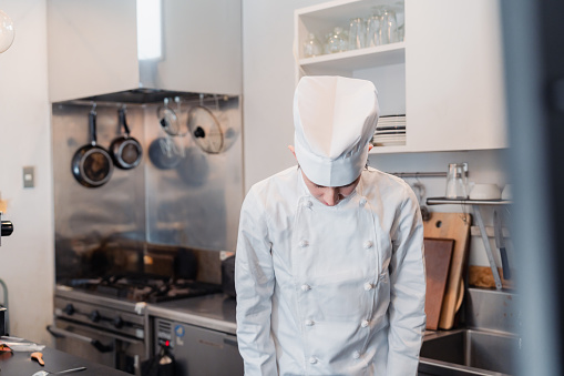 A male chef bowing in the kitchen