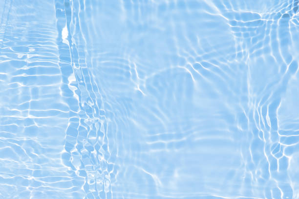 istock Defocus blurred transparent blue colored clear calm water surface texture with splashes and bubbles. Trendy abstract nature background. Water waves in sunlight with caustics. Blue water shinning 1453223895