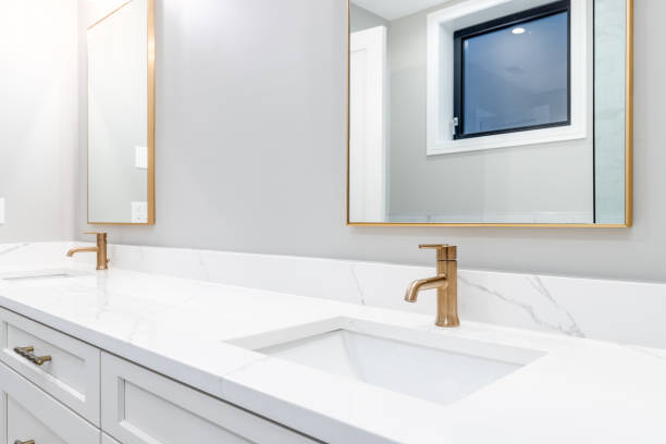 istock A bathroom's white vanity and gold faucet and mirrors. 1453224564