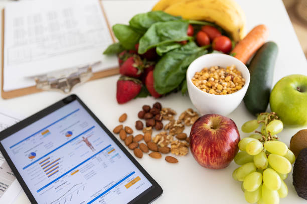 Digital nutritional program with heathy food and digital tablet charts stock photo