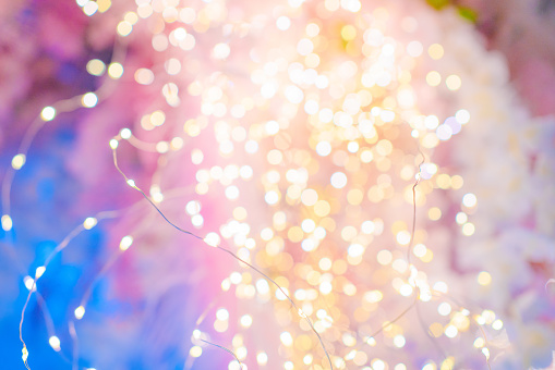 a cloud of multicolored particles in the air like sparkles on a dark background with a small depth of field. beautiful bokeh light effects with colored particles. background for holiday presentations