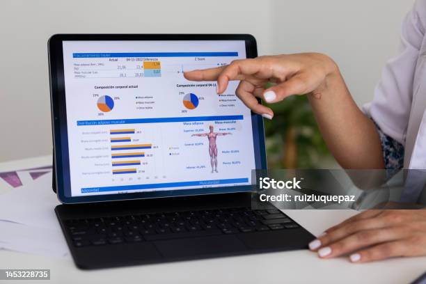 Close Up Of Hands Of A Female Nutricionist Doctor And Deportologist Pointing Out A Document In Her Computer During A Medical Consultation Stock Photo - Download Image Now