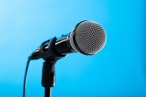 Single microphone on blue background.