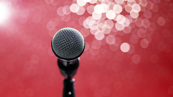 Single microphone on shiny red background.