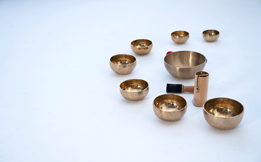 A set of acoustic singing (Tibetan) bowls on a white background with space for text.