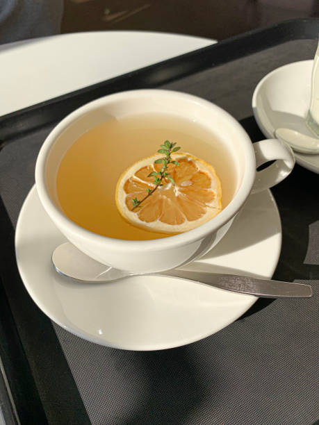istock Cup of tea with lemon on black background. 1453235124