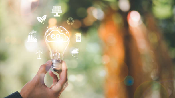 istock Industrial emissions pollute the environment and ecology.including climate change,Carbon Reduction Agreement from Renewable Energy Reduce greenhouse gas emissions,light bulb in human hand 1453236899