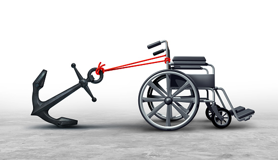 Challenges Faced By Handicapped as barriers and accessibility problems or Disabilities challenge as a wheelchair anchored with a heavy weight representing the disadvantaged with a disability as a 3d Illustration.