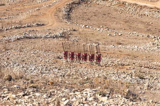 Karmiel, Israel, October 28, 2022 : Replicas of Roman battle shields and spears at place where Roman battle camp was located during siege of ancient Jotapata, in Tel Yodfat National park, in northern Israel