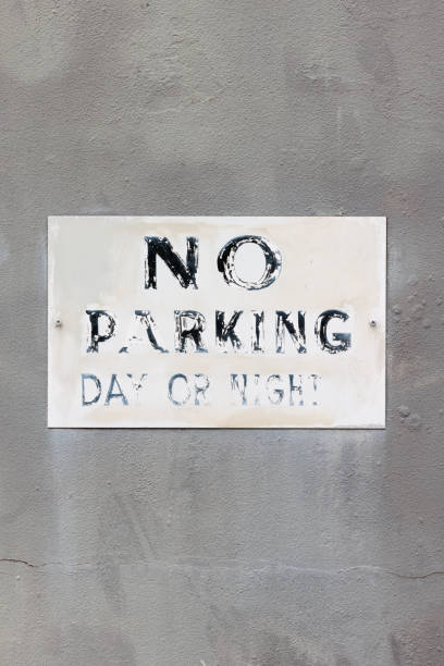istock Faded No parking sign on an old concrete wall 1453240293