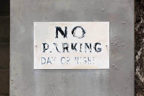 istock Faded No parking sign on an old concrete wall 1453240294