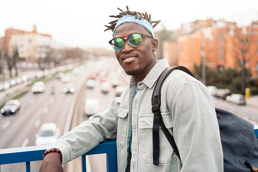 Cool and confident african man wearing sunglasses and looking at camera.