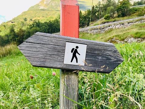 Wooden hiking trail signs arrows with hiker figures direction on a wooden sign post in woods