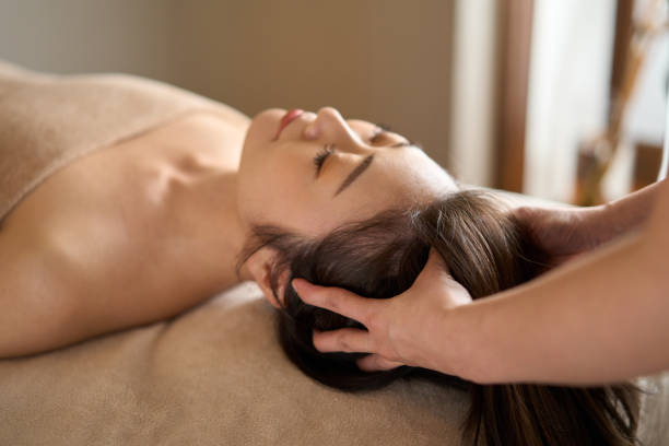 donna che riceve massaggio alla testa al salone di bellezza - spa treatment head massage health spa healthy lifestyle foto e immagini stock