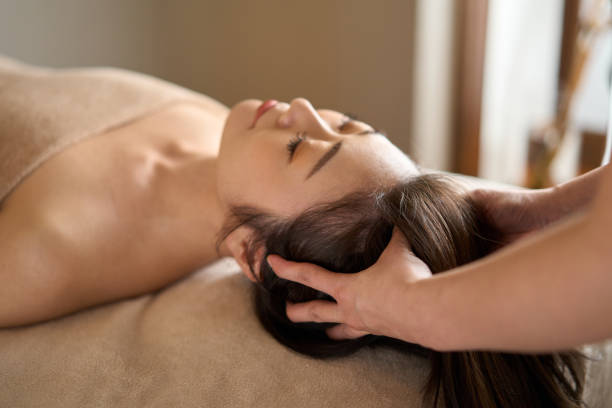 woman receiving head massage at beauty salon - massaging alternative medicine headache women imagens e fotografias de stock