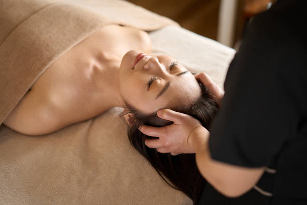 kobieta otrzymująca masaż głowy w salonie piękności - head massage headache massaging alternative therapy zdjęcia i obrazy z banku zdjęć