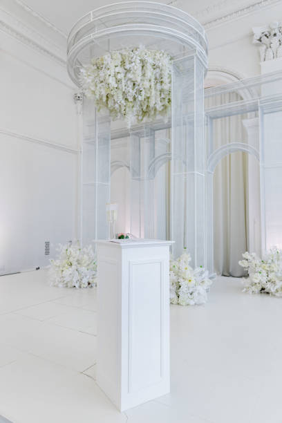 istock indoor wedding ceremony arch with table and flowers 1453244100