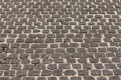 Tiles texture. Pattern of ancient german cobblestone in city downtown. Little granite paving stones. Antique gray pavements.