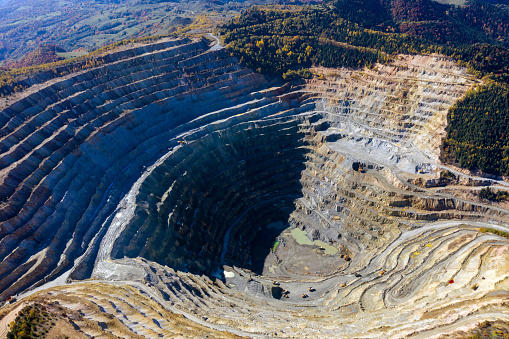 Flying above an open pit mine, copper excavation in Rosia Poieni, Romania. Aerial drone view
