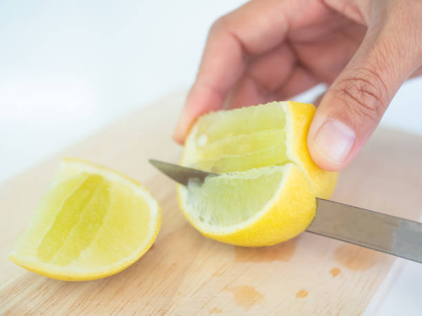 istock Knife Cutting Lemon Slice on wooden cutting board 1453247679