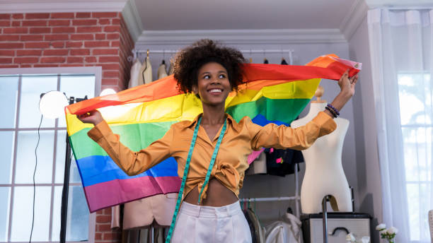 des femmes heureuses debout avec un drapeau arc-en-ciel de la fierté. - homosexual gay pride business rainbow photos et images de collection