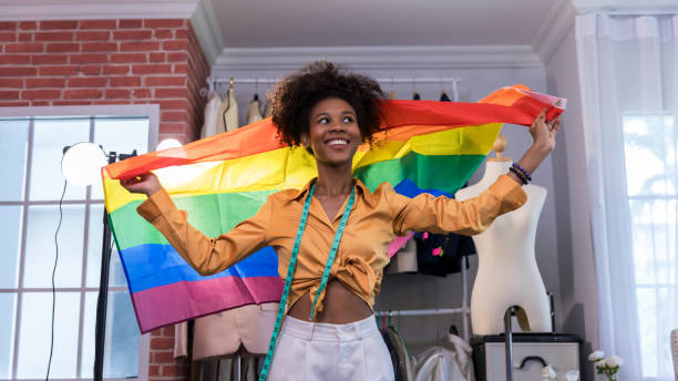 happy women standing with a pride rainbow flag. - homosexual gay pride business rainbow imagens e fotografias de stock