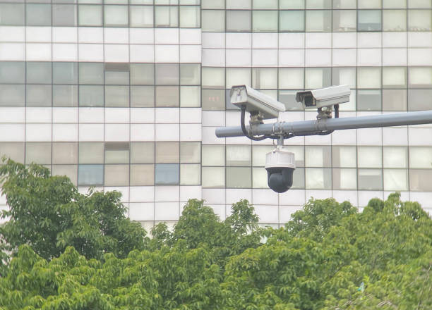 istock Surveillance cameras in front of blue sky 1453248571