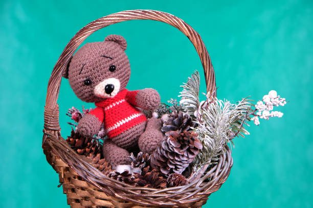 istock Toy bear in a Christmas basket with cones and a Christmas tree 1453252002