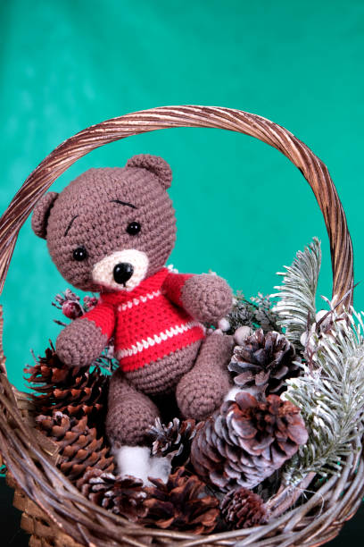istock Toy bear in a Christmas basket with cones and a Christmas tree 1453252004
