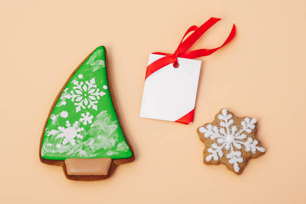 istock gingerbread cookie of Christmas tree and snowflake and white paper for congratulations text on color background, top view. Close-up. Happy new year and merry christmas concept 1453257287
