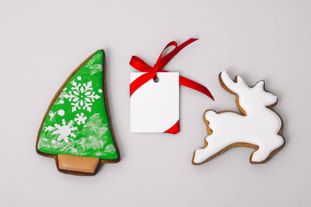 istock gingerbread cookie of Christmas tree and White deer and white paper for congratulations text on gray background, top view. Close-up. Happy new year and merry christmas concept 1453257305
