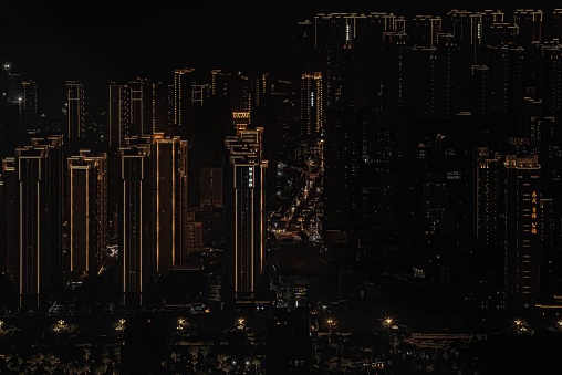 An aerial shot of a cityscape surrounded by buildings and lights at night