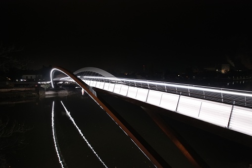 A closeup shot of an illuminated pedestrian bridge across the Elbe River in Nymburk at night