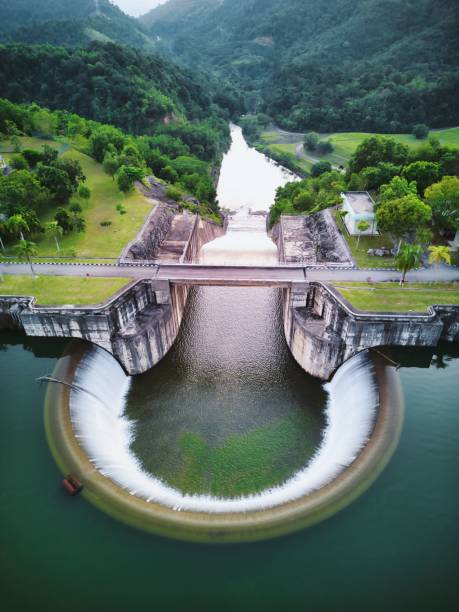 istock Aerial top view of a water dam construction surrounded by greenery 1453261694